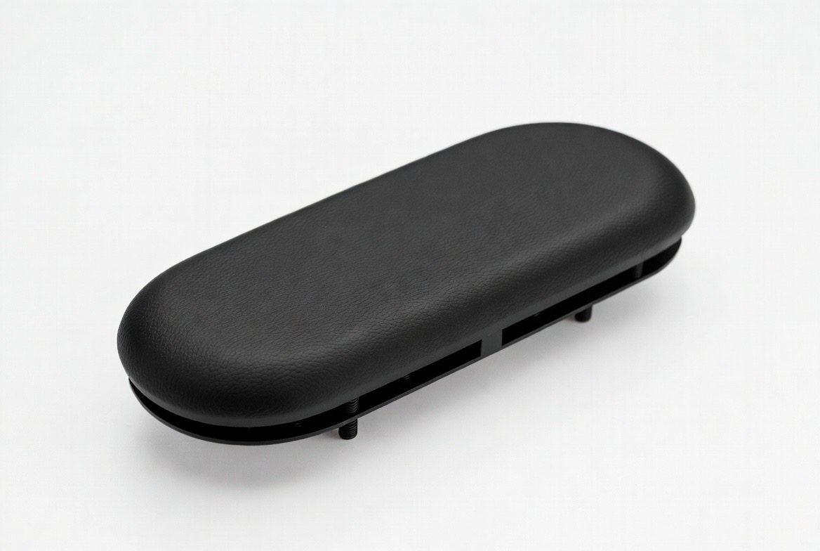 Integral skin urethane chair arm cap with molded-in insert hardware — custom furniture and seating component by Comcast Urethane